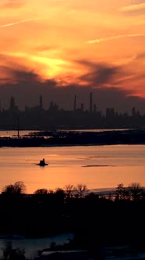 Beautiful view of the new york city skyline silhouetted against a vibrant orange and yellow sunset,