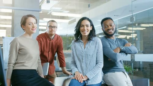 Diverse Group of Four Talented Young Professionals Having Team Building Conversation, Joking and Ha