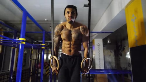 Muscular Afro American Sportsman Doing Push Ups on Gymnastic Rings at Gym Strong African Athlete