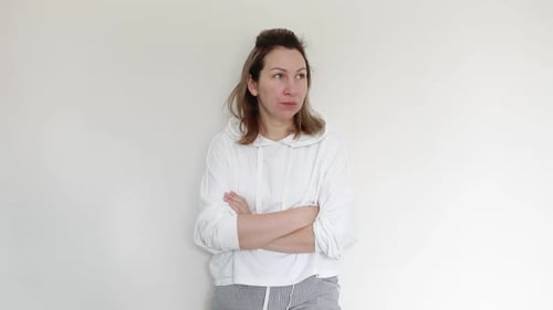 Woman Indoors With Arms Crossed Looking Around