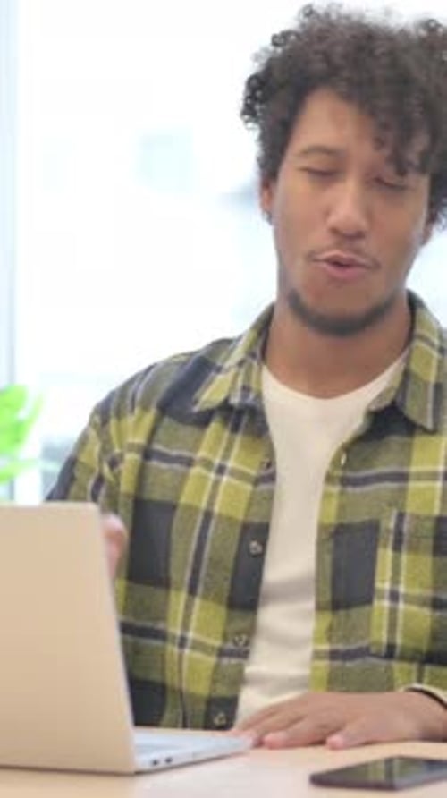 Online Video Chat on Laptop by African Man in Office, Vertical Video