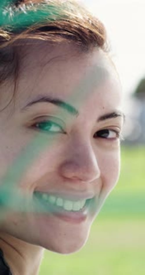 Visage, football et femme heureuse devant le filet, gardien de but et confiance en soi pour l'entraînement au jeu sur le terrain