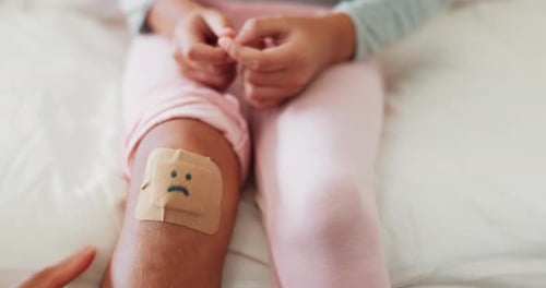 Knee bandage, child and hand for care, first aid support and love after a fall or accident