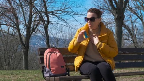 Femme respirant difficilement sur un banc de parc
