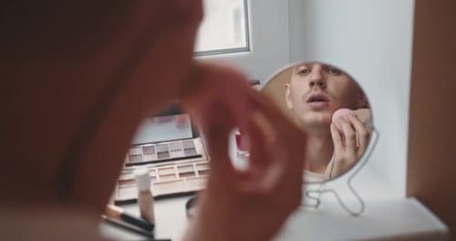 Young Adult Applying Makeup in Mirror
