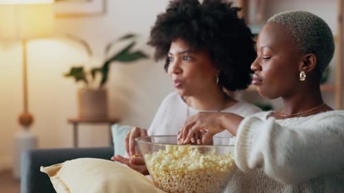 Two Women Enjoying Popcorn at Home
