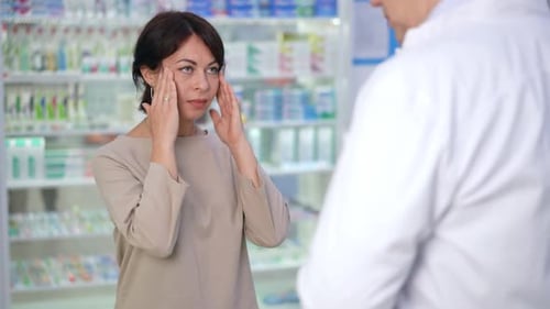 Woman Consulting Pharmacist about Medicine at Pharmacy