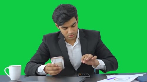 Sad Indian businessman counting the money Green screen
