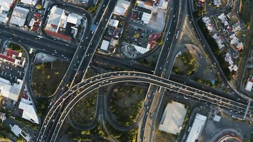 Aerial view of a highway intersection with traffic in a sunset