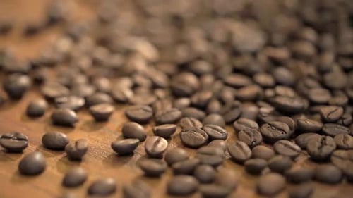 Roasted Coffee Beans Poured onto Wooden Table
