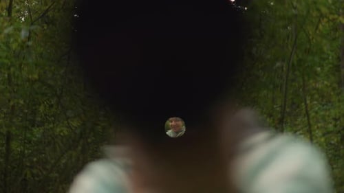 Une personne scrute la lunette tandis que l'environnement reste légèrement flou La personne examine attentivement son