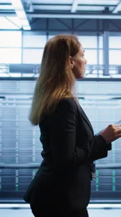 Vertical Video Woman in Data Center Making Sure Rigs are Functioning Optimally