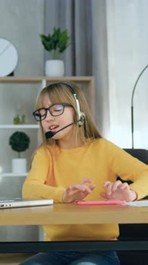 Girl with Headset Using Tablet at Desk Indoors