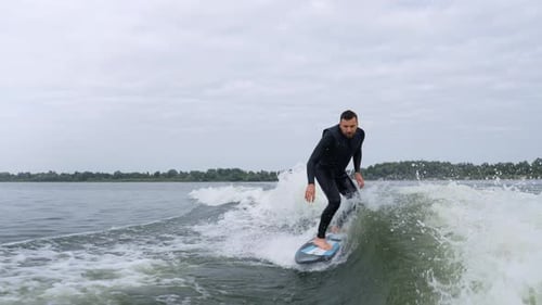 Man wake surfing on wavy lake