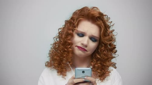 Cheerful Woman Typing Text Message Smartphone at Grey Background. Closeup Focused Girl