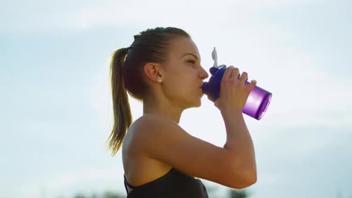 Woman Drinking Water During Outdoor Workout