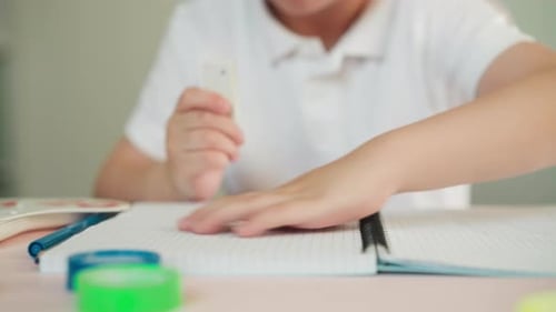 Boy Doing Homework at Table with Supplies