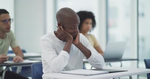 A student looking stressed out during a lesson in a university classroom