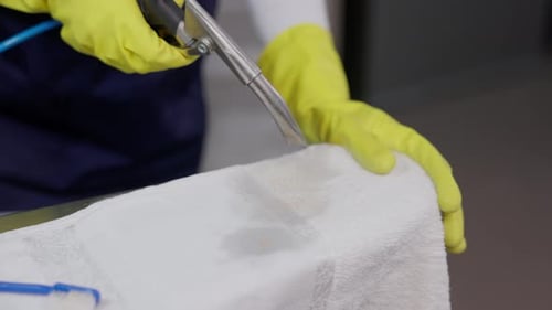 Hands In Gloves Drying Spot On Towel With Stain Removed At Laundry Shop. closeup shot