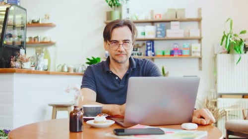 A Focused Professional Diligently Working on Their Laptop in a Cozy Coffee Shop Setting Taking