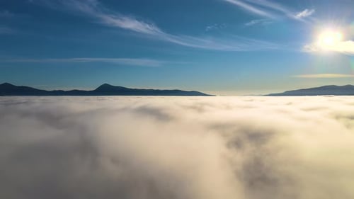 View From Above of Vibrant Landscape of Foggy Clouds Covering Mountain Hills and Village Houses at