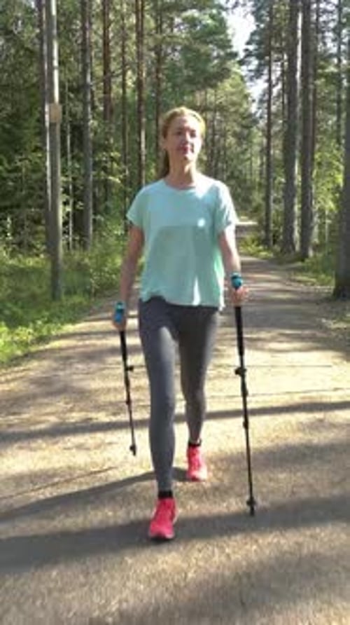 Active Woman Doing Nordic Walking in a Park