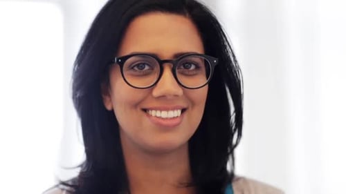 Smiling woman with glasses looking at camera