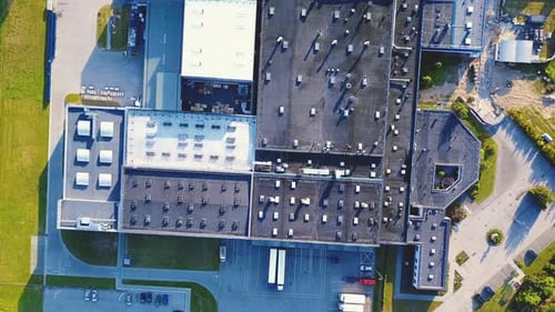 Aerial shot of industrial warehouse. Loading hub and many trucks with cargo trailers. Aerial view of