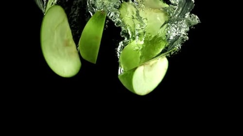 Pieces of Green Apples Fall Under the Water Filmed on a Highspeed Camera at 1000 Fps