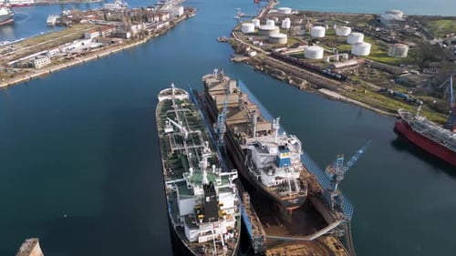 Aerial View of a Ship Repair Yard with Dry Docks Cranes and Cargo Vessels in an Industrial Port