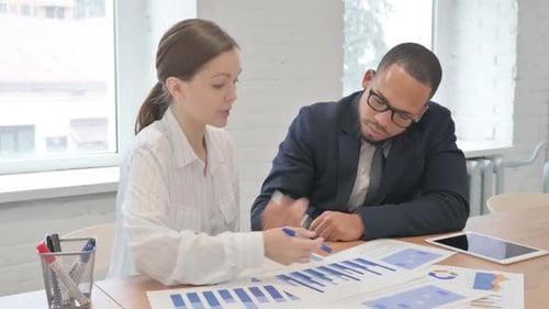 Mixed Race Business People Doing Paperwork in Office