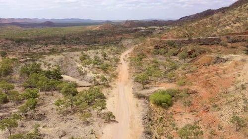 Arid dry landscape with dirt road aerial in Outback Queensland, Australia