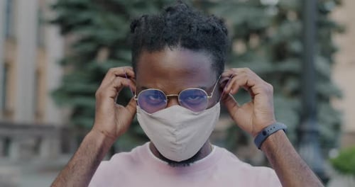 Young Adult Puts on Protective Face Mask