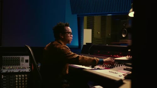 Music Producer Operating Mixing Console in Control Room