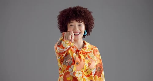 Glückliche Frau, Gesicht und auf dich zeigend im Studio mit Mode zur Auswahl auf grauem Hintergrund