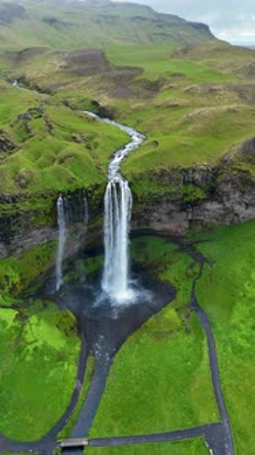 Majestic Seljalandsfoss Waterfall Cascading Through Lush Green Icelandic Landscape
