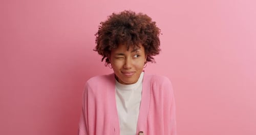 Schöne lockige Frau schließt die Augen und erwartet, dass etwas passiert ist, hält den Atem an