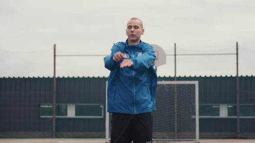 Man in Blue Jacket Warming Up on Court