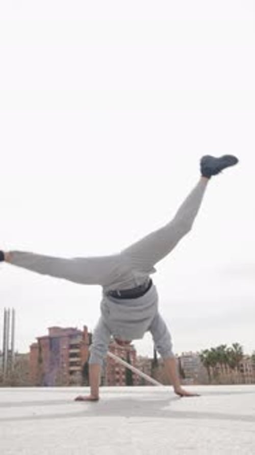 Breakdancer Performs Acrobatics on Urban Rooftop
