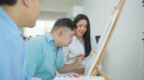 Young Adults Painting Together on Canvas Indoors