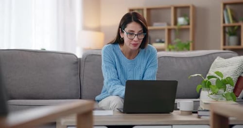 Woman Working on Laptop at Home on Couch