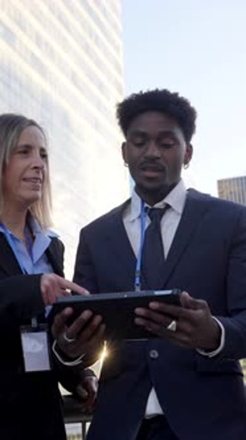 Business People Discussing Tablet Outside Skyscraper Building