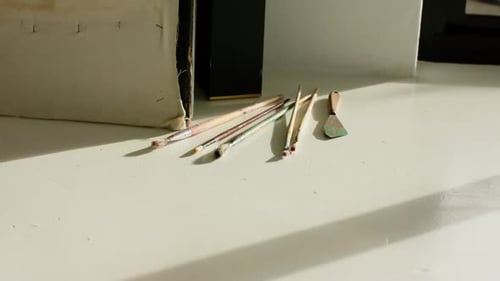 Daylight streaming through window is casting shadows, highlighting brushes to reveal changing light