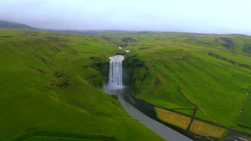 Aerial View of Waterfall Flowing Into River Valley