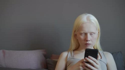 Woman Using Smartphone Device Indoors on Couch