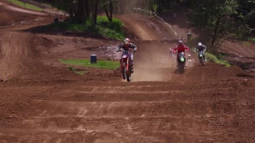 Motocross Racers Jumping on a Dirt Track