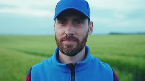Close Up Face Young Attractive Farmer Man with Beard Looking to Camera in Field Harvesting Organic