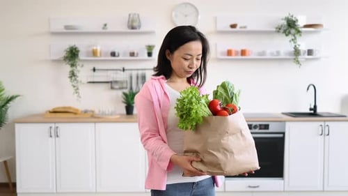 Woman with Groceries in Kitchen