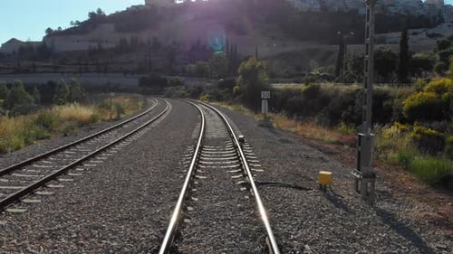 Curving Train Tracks Through Rural Landscape in Daytime