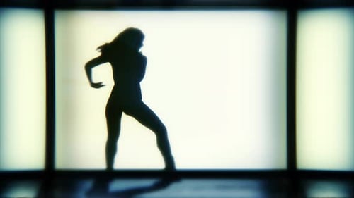 Eine Silhouette-Frau tanzt lässig vor einem hellen Bühnenhintergrund